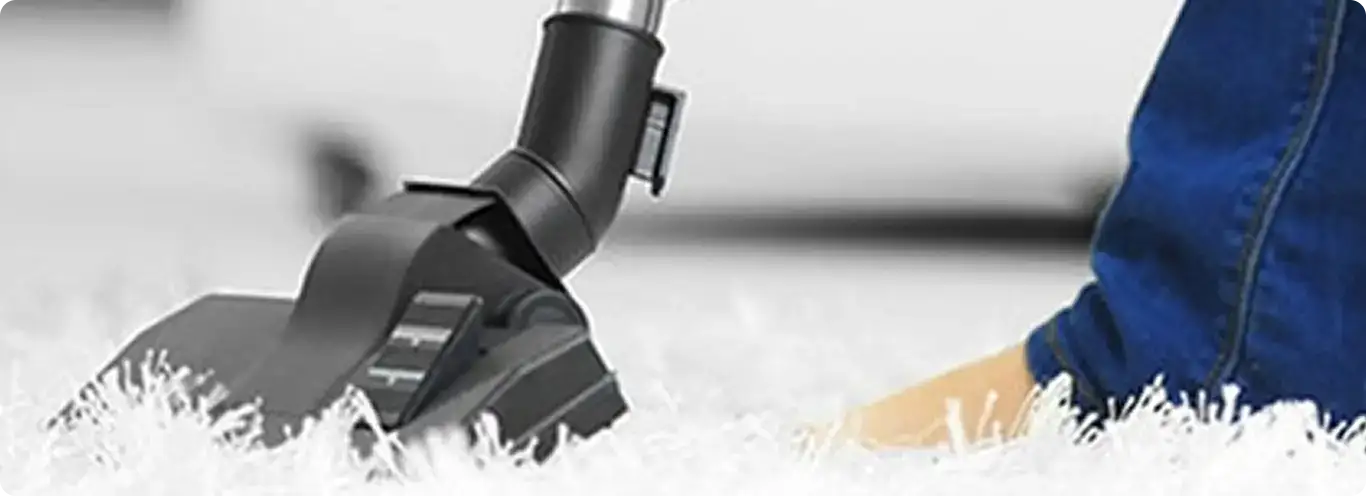 Close-up of a professional vacuuming a white carpet in Bolingbrook.