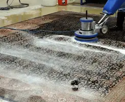 Professional rug cleaning with a rotary floor machine and shampoo foam, deep-cleaning an area rug, in Naperville, IL.